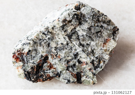 sample of raw foyaite rock on white marble 131062127