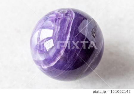 polished ball from charoite rock on white marble 131062142