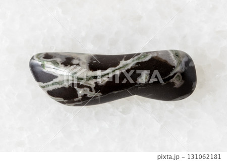 sample of tumbled hornfels mineral on white marble sample of tumbled hornfels mineral on white marble 131062181
