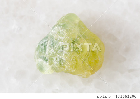 raw yellow green sapphire corundum on white marble 131062206
