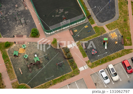 Playground, sports court and parking view from above. Community playground and park area, featuring equipment for children and a basketball court. aerial view Playground, sports court and parking view from above. Community playground and park area, featuring equipment for children and a basketball court. aerial view 131062797