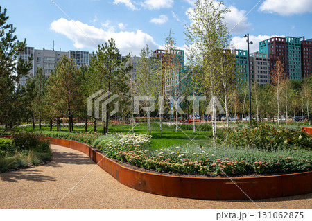 Urban park landscape with greenery and recreational pathways in city, sunny day. modern buildings in background. improvement, beautification, renovation of urban environment, improving quality of life Urban park landscape with greenery and recreational pathways in city, sunny day. modern buildings in background. improvement, beautification, renovation of urban environment, improving quality of life 131062875