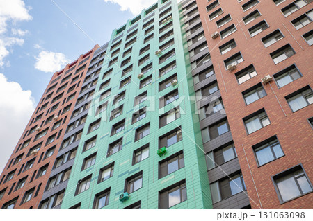 Red and green facade with windows of a modern residential apartment building, residential complex. view from below from street. 131063098
