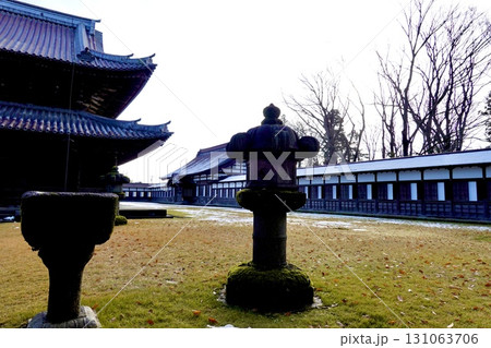 瑞龍寺　雪が残る境内に石灯籠と仏殿と南西回廊の建物が見える風景　富山県高岡市 131063706