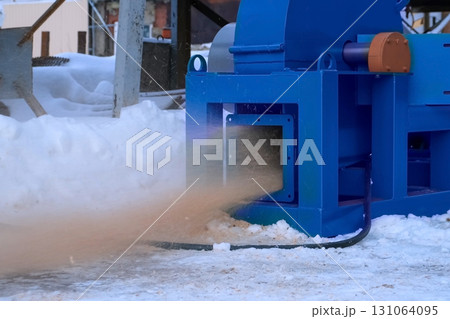 Wooden sawdust blowing of chopping machine outdoors at woodworking plant. 131064095