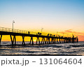 Stunning sunset at Glenelg Beach jetty, with silhouettes of people 131064604