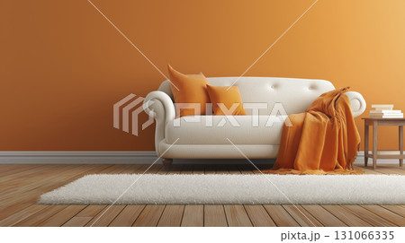 Modern living room with white sofa, orange pillows, and matching throw blanket against orange wall, with small wooden side table and books 131066335