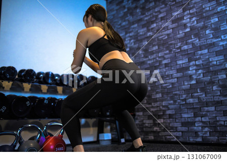 スクワットでお尻を鍛える女性の後ろ姿　ジムで運動するかっこいい女性　ヒップアップ　筋トレ女子　 131067009