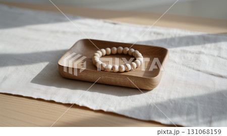Minimalist beaded bracelet on wooden plate symbolizing mindfulness Minimalist beaded bracelet on wooden plate symbolizing mindfulness 131068159
