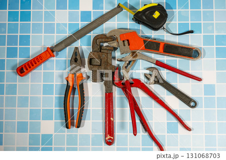 Plumbing tools lying on blue tiles ready for home improvement repairing 131068703