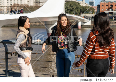 Young women talking next to the puente de la mujer in buenos aires, argentina 131068777