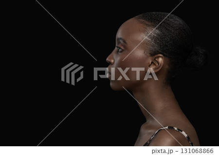 Side Profile Portrait of Young Black Woman on Dark Background Side Profile Portrait of Young Black Woman on Dark Background 131068866