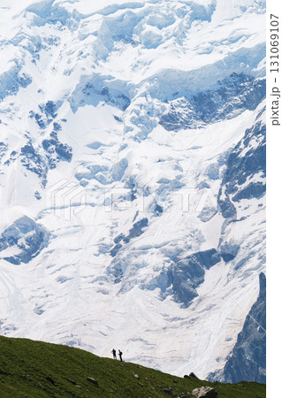 Travelers on the background of a glacier and high snowy mountains 131069107