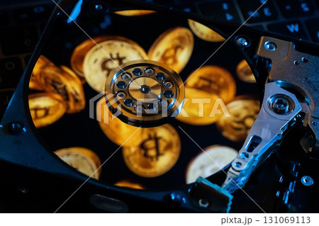 A hard drive decorated with gold bitcoin symbols 131069113