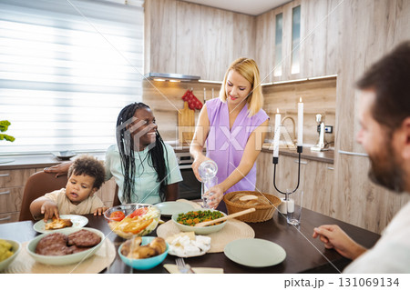 Family shares a hearty meal at the kitchen table 131069134