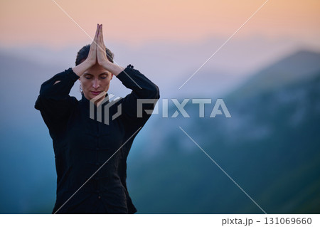Woman practicing Tai Chi in traditional black outfit on mountain at sunrise, arms outstretched in meditation pose focusing on balance, energy, and mindfulness in nature. Woman practicing Tai Chi in traditional black outfit on mountain at sunrise, arms outstretched in meditation pose focusing on balance, energy, and mindfulness in nature. 131069660