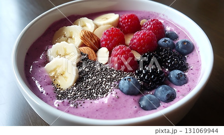 Close up reveals a purple smoothie bowl topped with fresh berries and almonds Close up reveals a purple smoothie bowl topped with fresh berries and almonds 131069944