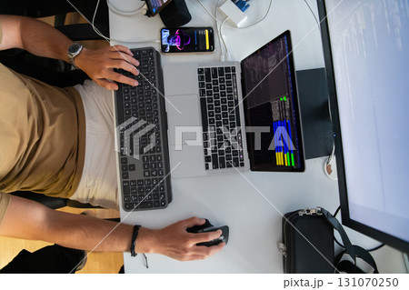 Top view of programmer diligently testing smartphone applications while sitting in their office. 131070250