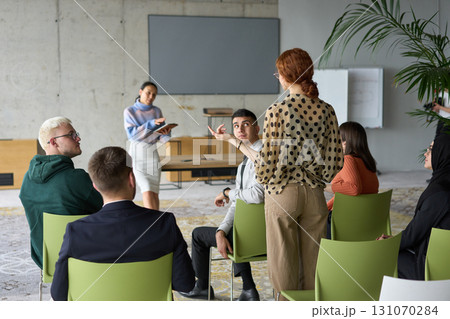 A diverse group of business professionals sits attentively in a modern office, actively participating in a training session led by an instructor, focusing on the latest technological advancements in A diverse group of business professionals sits attentively in a modern office, actively participating in a training session led by an instructor, focusing on the latest technological advancements in 131070284