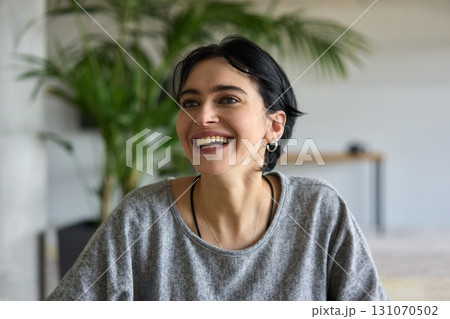 A close up portrait of a young businesswoman engaged in a professional meeting, confidently discussing ideas and strategies with her colleagues 131070502