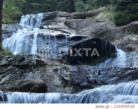 Woman practicing Tai Chi in nature, wearing a traditional black martial arts uniform, standing gracefully near a waterfall, focused on meditation and balance. Healthy lifestyle in asian culture Woman practicing Tai Chi in nature, wearing a traditional black martial arts uniform, standing gracefully near a waterfall, focused on meditation and balance. Healthy lifestyle in asian culture 131070530