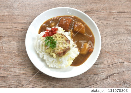 fried pork hamburg steak topping plain rice dressing potato and carrot in Japanese curry on plate  131070808