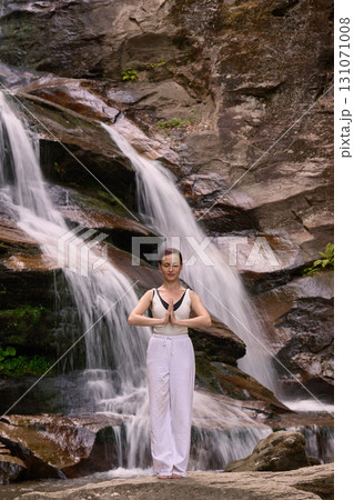 woman performing slow tai chi movements near a waterfall and river at sunset capturing harmony balance and fitness in nature woman performing slow tai chi movements near a waterfall and river at sunset capturing harmony balance and fitness in nature 131071008