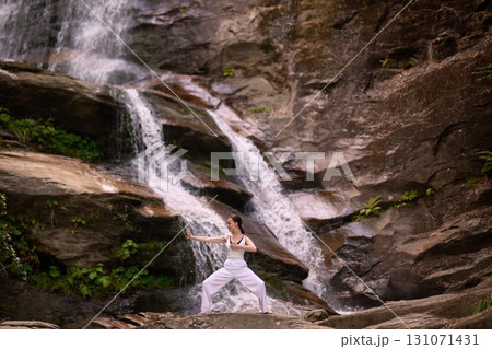 woman performing slow tai chi movements near a waterfall and river at sunset capturing harmony balance and fitness in nature woman performing slow tai chi movements near a waterfall and river at sunset capturing harmony balance and fitness in nature 131071431