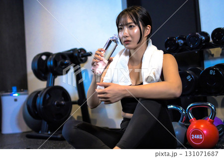 給水しながら休憩する女性 ペットボトル ジムで運動するかっこいい女性 トリミングアップ 給水しながら休憩する女性 ペットボトル ジムで運動するかっこいい女性 トリミングアップ 131071687