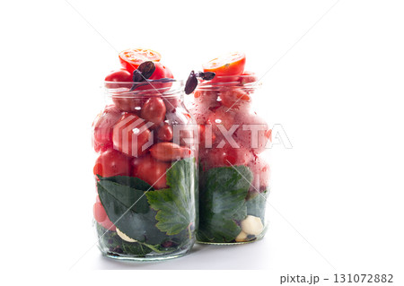 Homemade red tomatoes with herbs in a jar 131072882