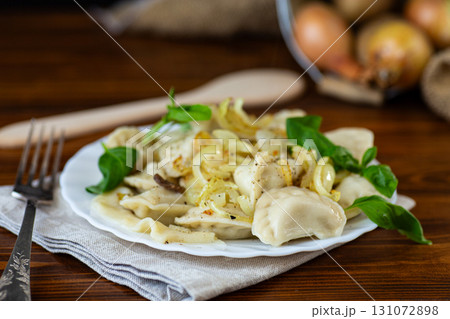 Homemade dumplings with potatoes and onions on a plate Homemade dumplings with potatoes and onions on a plate 131072898