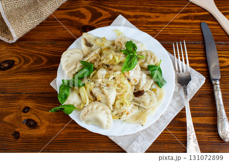 Hot dumplings with onions and fresh herbs 131072899