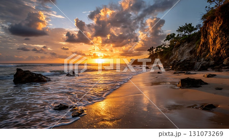 Dramatic Beach Sunset with Clouds, Cliffside, and Golden Light Reflections on Water 131073269