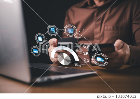A person using a smartphone and holding a credit card conducts online shopping while monitoring credit score and payment transactions, with digital icons and analytics overlaying the scene. 131074012