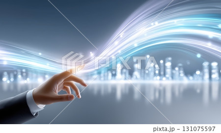 Human hand touching glowing light trails against a futuristic city skyline, representing technology and connection 131075597
