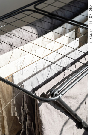 Washed clothes drying on rack near window. Laundry day concept 131076068