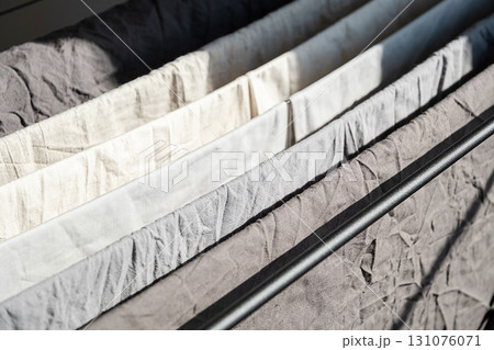 Clean laundry drying on clothes horse in rows, showcasing simple and ecofriendly household chore. 131076071