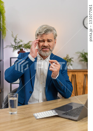 Middle-aged businessman massages temples swallows headache pill drinks water again to return to work Middle-aged businessman massages temples swallows headache pill drinks water again to return to work 131077061