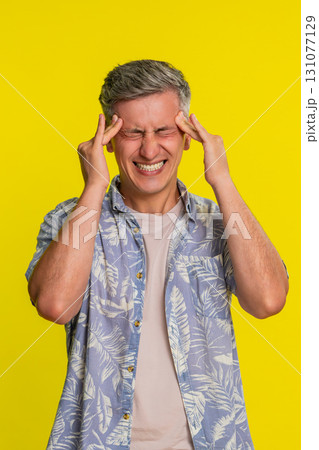 Adult man rubbing forehead with closed eyes suffering from strong headache pain visible discomfort 131077129