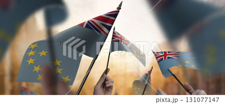 Tuvalu flags in their hands on a blurred urban background 131077147