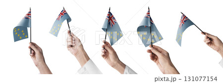 The Tuvalu flag in hand in different angles on a white background 131077154