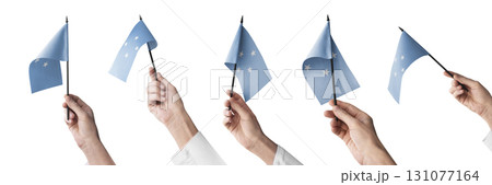 The Federated States Micronesia flag in hand in different angles on a white background The Federated States Micronesia flag in hand in different angles on a white background 131077164