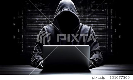 hacker in hood hacking computer at night 131077509