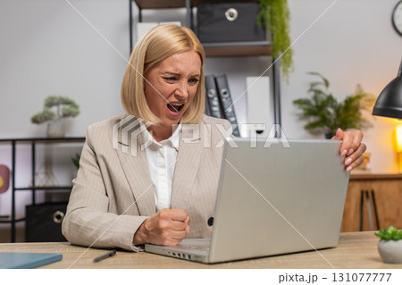 Displeased sad businesswoman using laptop becoming surprised lottery results bad news computer virus 131077777