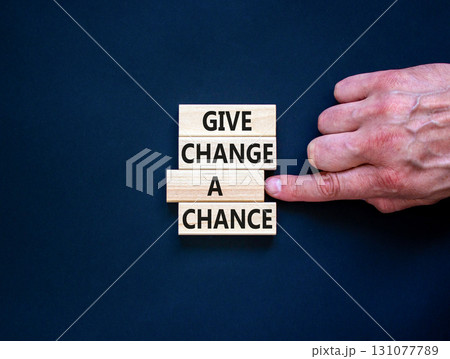 Give change a chance symbol. Concept words phrase Give change a chance on beautiful wooden blocks. Beautiful black paper background. Businessman's hand Business Give change a chance concept Copy space 131077789