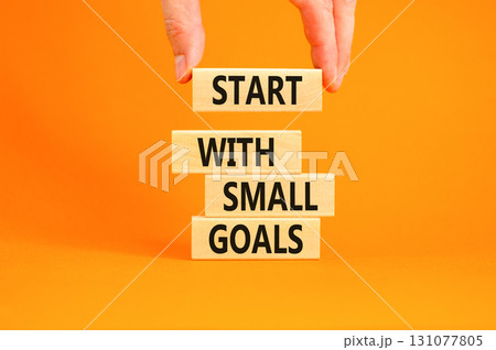 Start with small goals symbol. Concept words phrase Start with small goals on beautiful wooden blocks. Beautiful orange background Businessman's hand Business Start with small goals concept Copy space Start with small goals symbol. Concept words phrase Start with small goals on beautiful wooden blocks. Beautiful orange background Businessman's hand Business Start with small goals concept Copy space 131077805