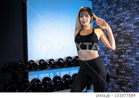ポージングする鍛えた女性　ジムで運動するかっこいい女性　ストレッチ　筋トレ女子　 131077884