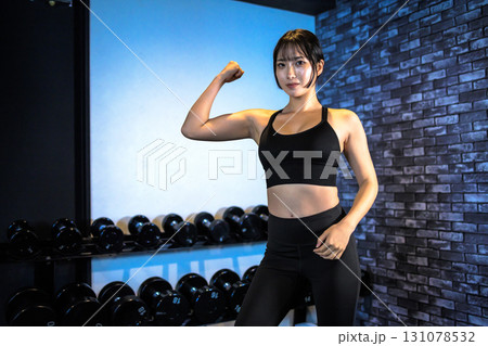 力こぶをつくる女性　ジムで運動するかっこいい女性　上半身　筋トレ女子　 131078532