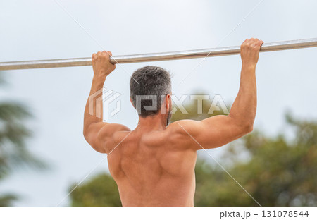 Sport lifestyle. Muscular biceps and triceps. Strong athlete. Man pullup. Muscular man sportsman with strong back muscle. Sport pullup workout. Sport training. Man sportsman do pulling exercise 131078544