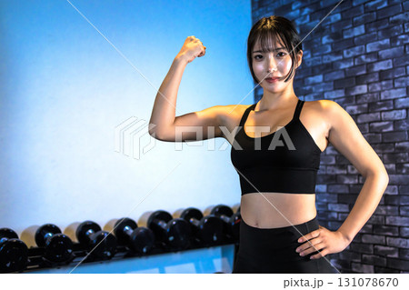 力こぶをつくる女性　ジムで運動するかっこいい女性　上半身　筋トレ女子　トリミングアップ 131078670